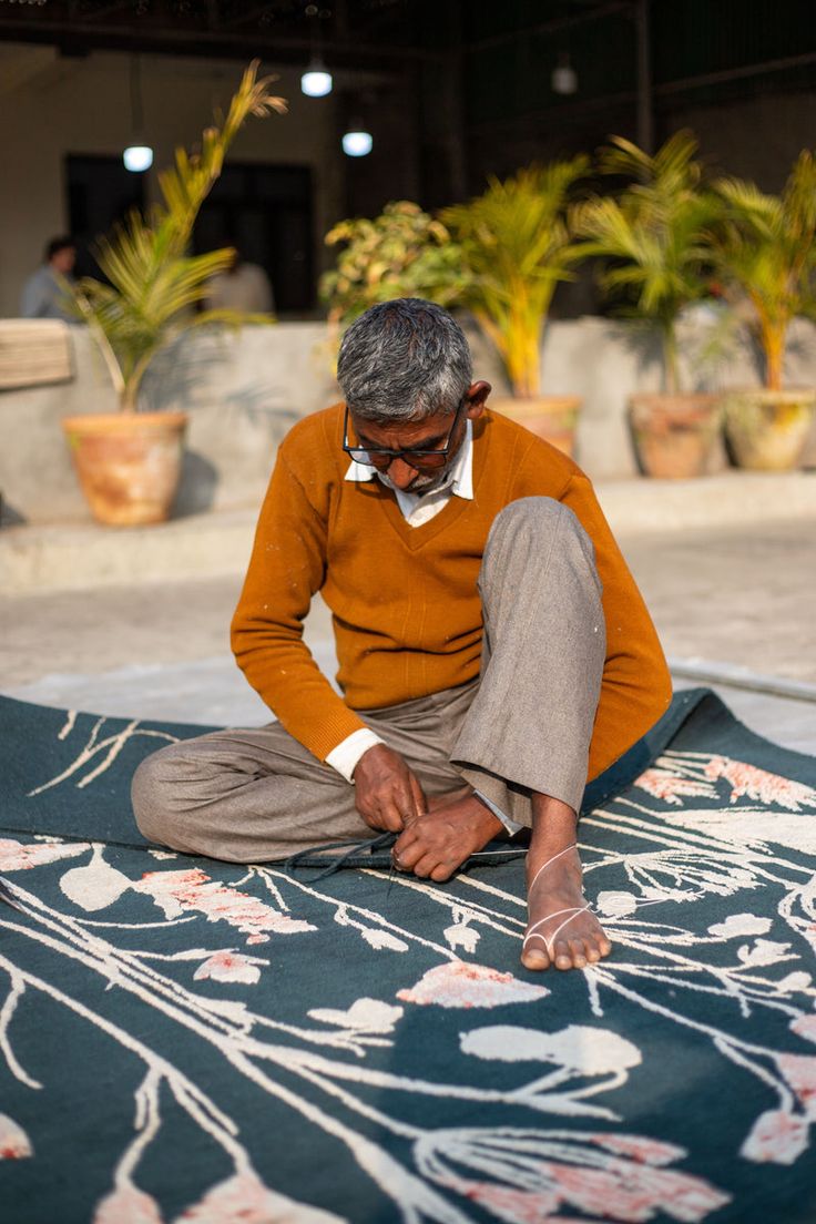 Bhadohi carpet artisan hand-finishing a floral rug in a local workshop